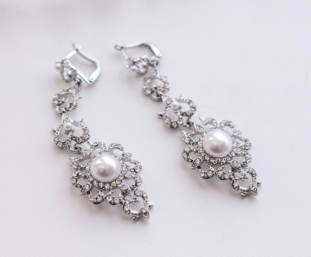 wedding-earrings-white-surface_131240-1570